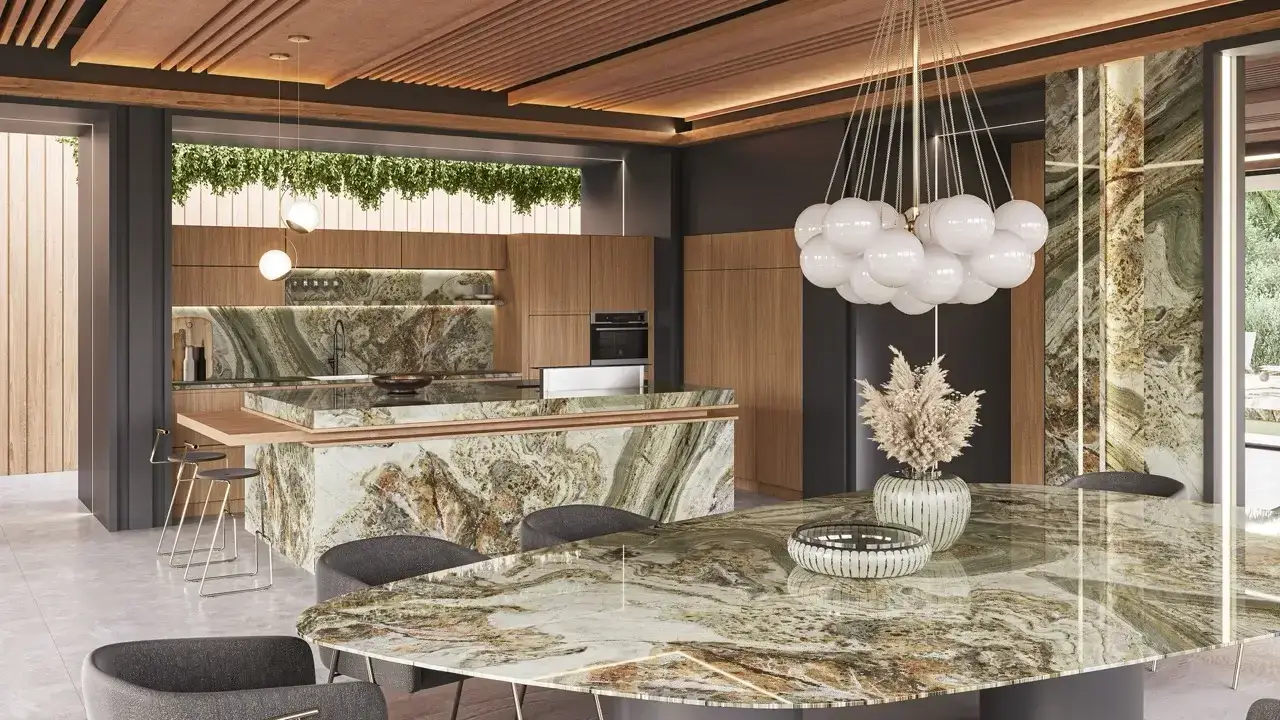 Modern kitchen and dining area with green quartzite countertops, wooden cabinets, white bubble chandelier.