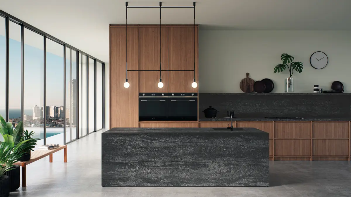 Modern luxury kitchen with wood cabinets, black countertops, and city view from large windows.