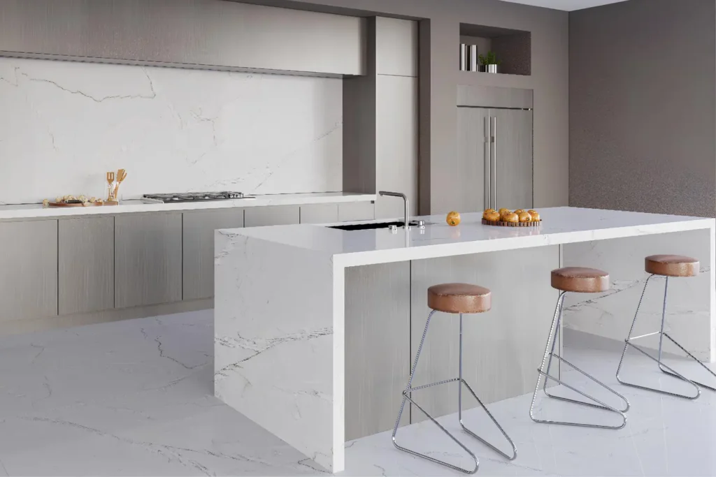 Modern kitchen interior with white quartzite countertops, light gray cabinets, and bar stools.