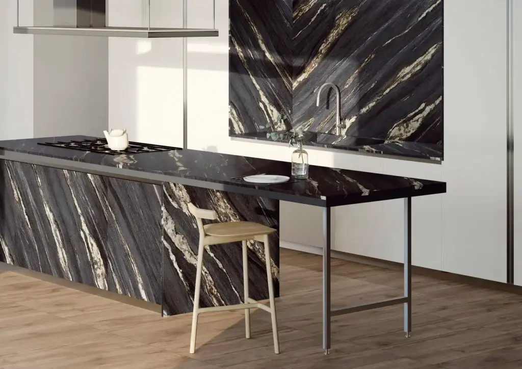 Modern kitchen with black marble countertops, island with integrated stove, matching backsplash, and wooden flooring.