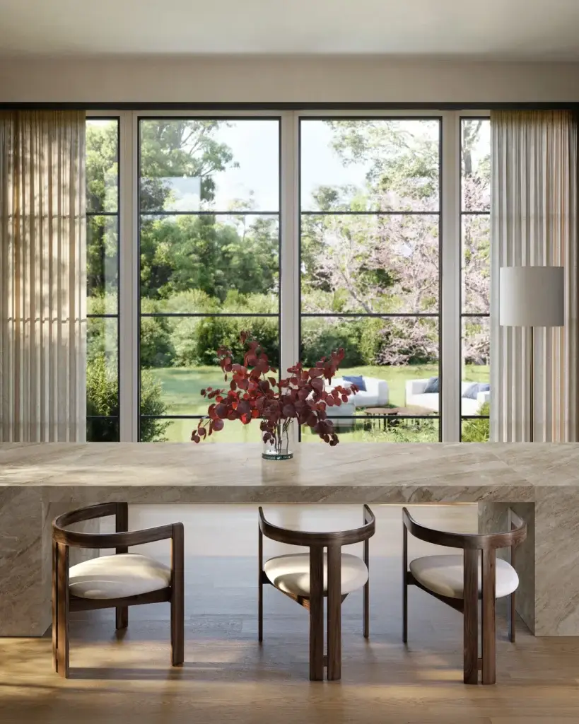 Modern dining room with a large stone table, wooden chairs, and a panoramic window overlooking a lush garden.