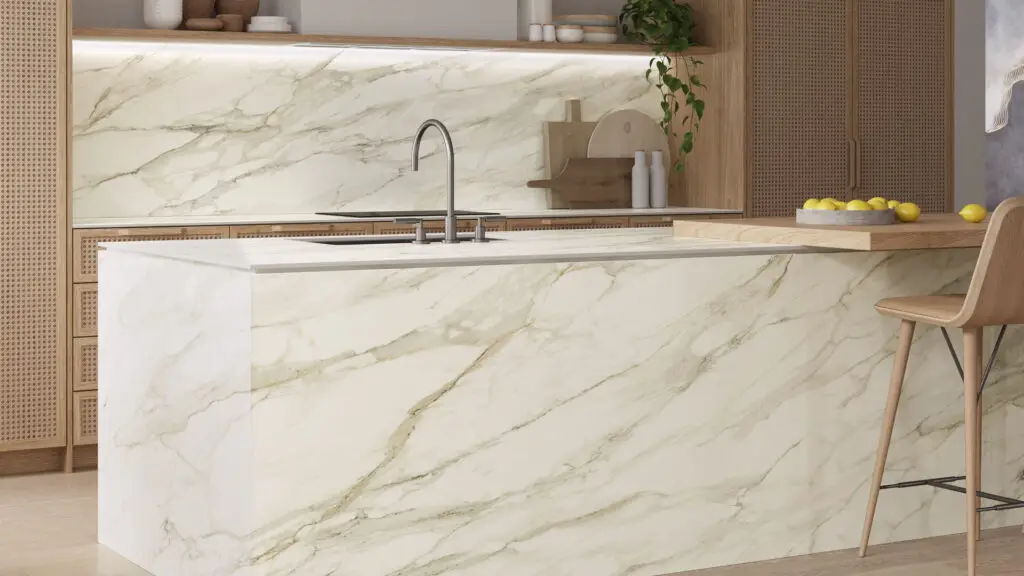 Modern kitchen with white marble island, faucet, wood accents, and bar stool.