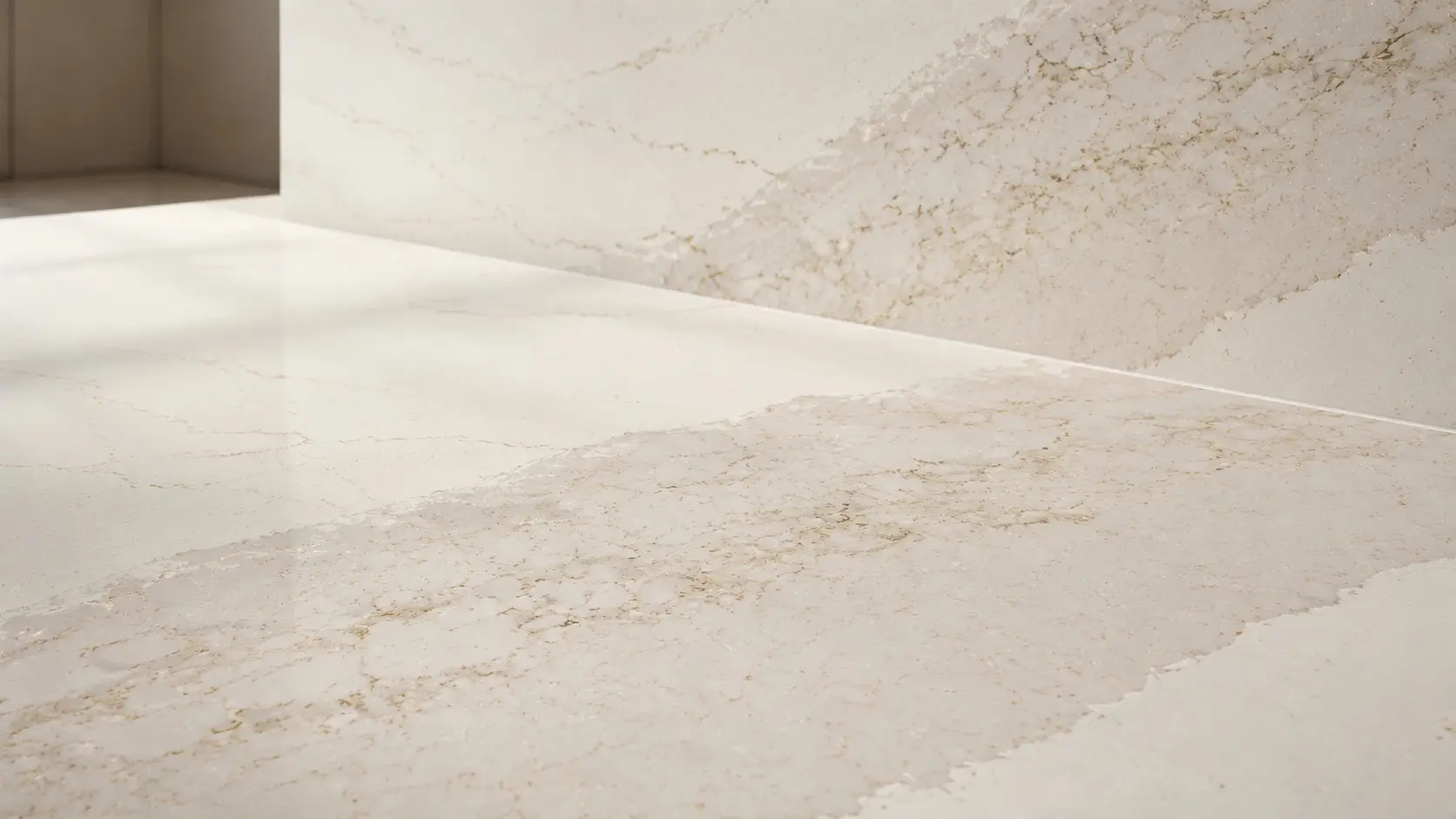 Close-up of Cambria Brittanicca Gold Cool on a kitchen countertop and backsplash with soft gold veining.