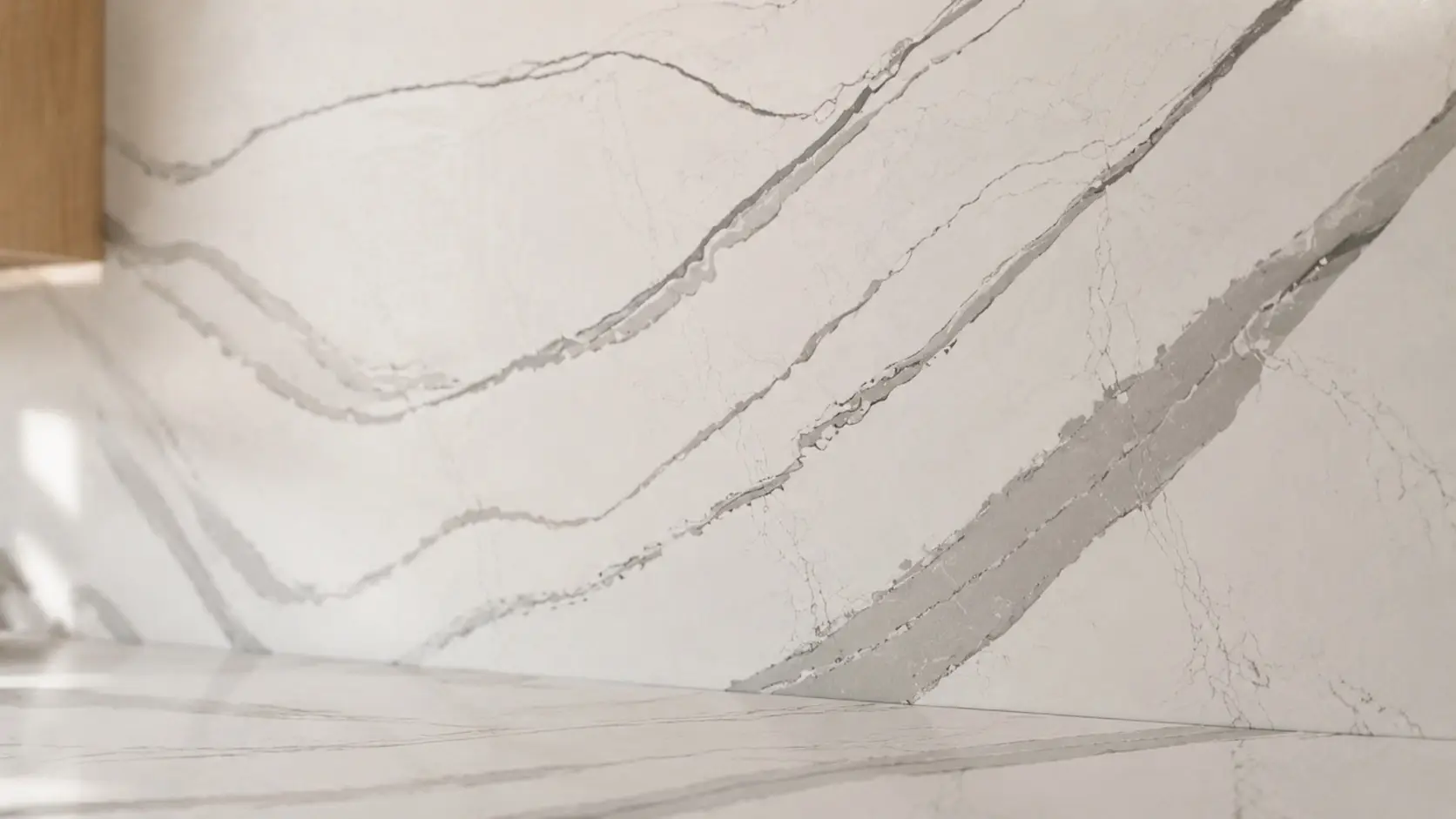 Cambria Brittanicca Warm quartz applied to a kitchen countertop and backsplash with layered gray veining.