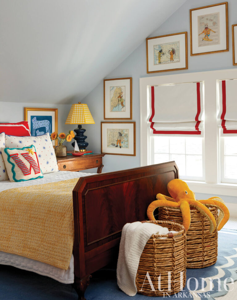 Boy’s bedroom with light blue walls, an heirloom wood bed, framed animal prints, a yellow lamp, and woven baskets.
