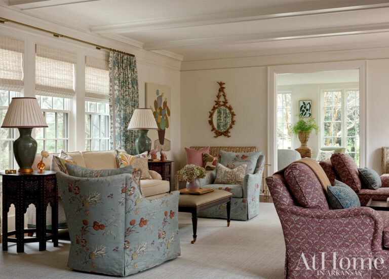 Renovated traditional living room with blue floral chairs, burgundy sofas and layered patterned fabrics