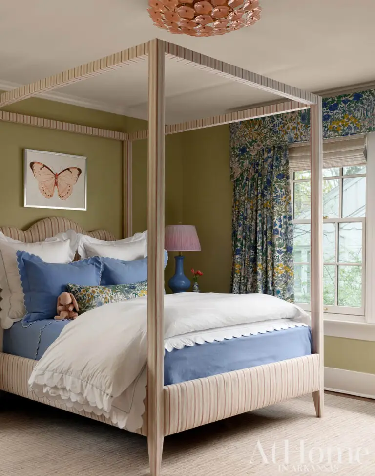 Traditional bedroom with a striped four-poster bed, floral curtains, olive green walls and blue accents